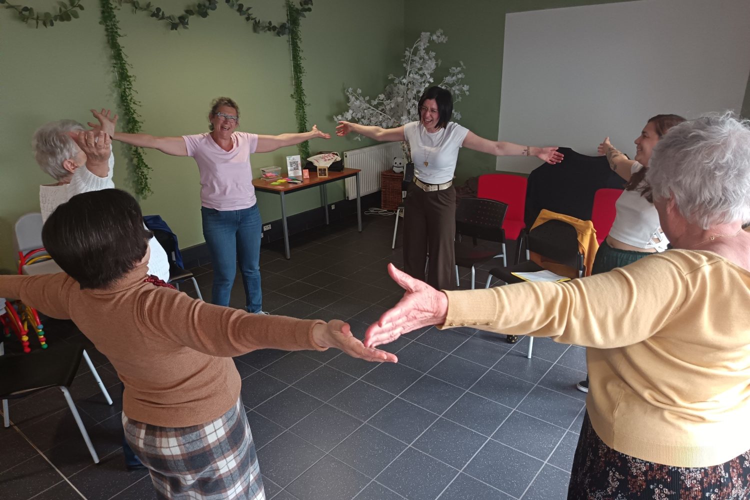 Séance de yoga du rire - les participantes sont en cercle, joyeuses et rigolent les bras ouverts.